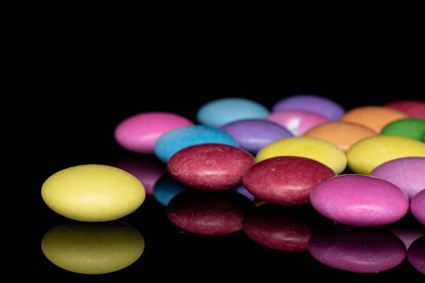 istock Sweet colourful candy isolated on black glass 1207079460