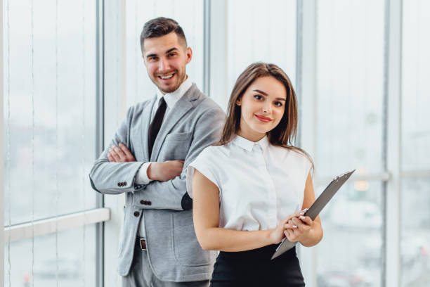 Excited business partners standing side by side, motivated for better teamwork result. Profitable partnership concept. Excited business partners standing side by side, motivated for better teamwork result. side by side stock pictures, royalty-free photos & images