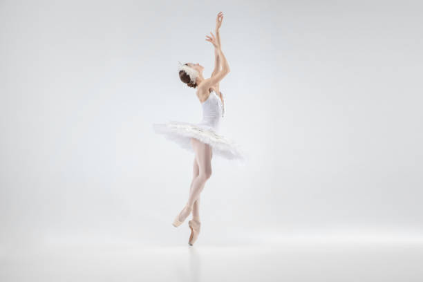 istock Young graceful ballerina on white studio background 1207080130