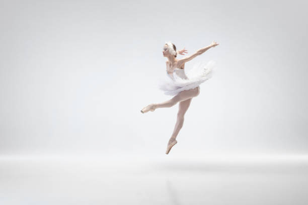 istock Young graceful ballerina on white studio background 1207080351