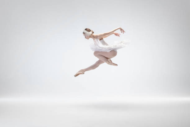 istock Young graceful ballerina on white studio background 1207080375