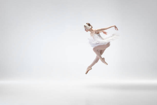 istock Young graceful ballerina on white studio background 1207080376
