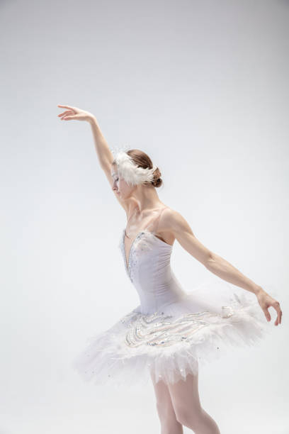 istock Young graceful ballerina on white studio background 1207080475