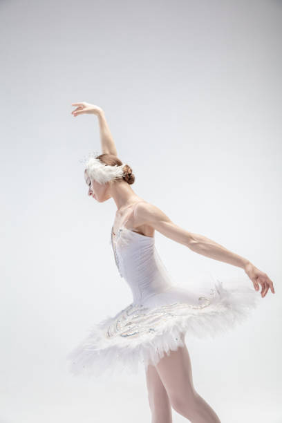 istock Young graceful ballerina on white studio background 1207080488