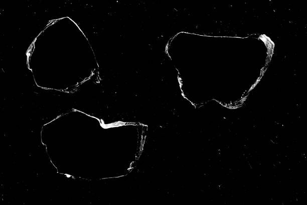 istock hole in the glass with cracks isolated on a black background. 1207080578