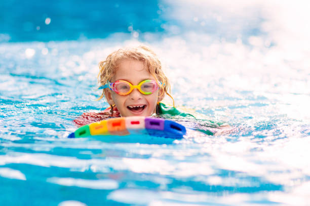 istock Child learning to swim. Kids in swimming pool. 1207081446