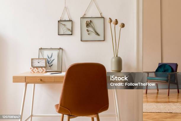 Interior Design Of Scandinavian Open Space With Mock Up Photo Frames Wooden Desk Retro Armchair Flowers Books Office And Personal Accessories Stylish Neutral Home Staging Beige Walls Template Stock Photo - Download Image Now