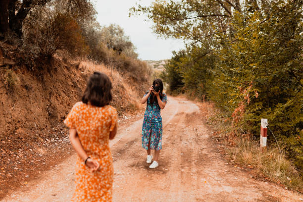 istock Two young women taking photos on a path near a forest 1207081815