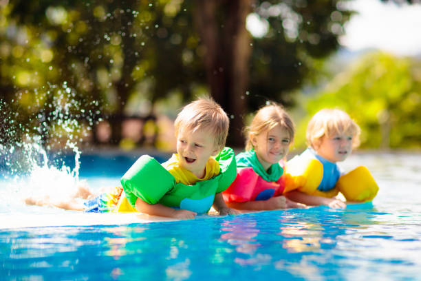 istock Kids in swimming pool. Life jacket for child. 1207082764