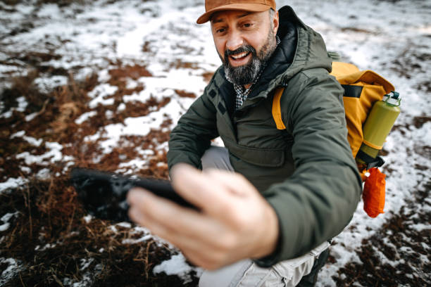 istock Happy mature hiker taking a selfie on a mountain during winter day 1207082791