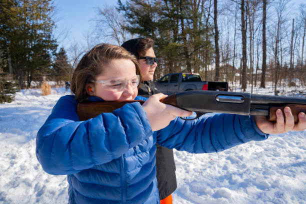 istock Two teens shooting a shotgun on a snowy winter day 1207085920
