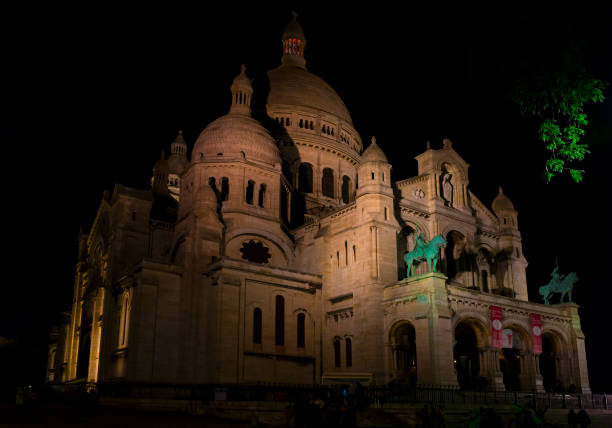 Paris, France - November 11, 2019: Night photograph of the Basilica of the Sacred Heart (Sacre Coeur) in Montmartre hill, from Azais street