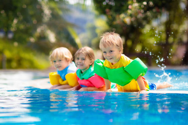 istock Kids in swimming pool. Life jacket for child. 1207087088