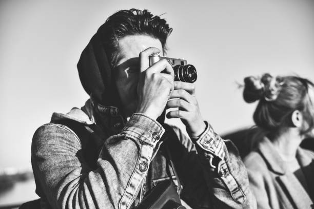 Low key picture of a photographer holding a kamera on his eyes . Isolatet on Black.