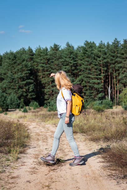 istock Woman hiker with backpack walking on footpath in nature 1207090853