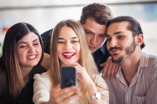 istock Group of friends looking at a mobile phone 1207091159