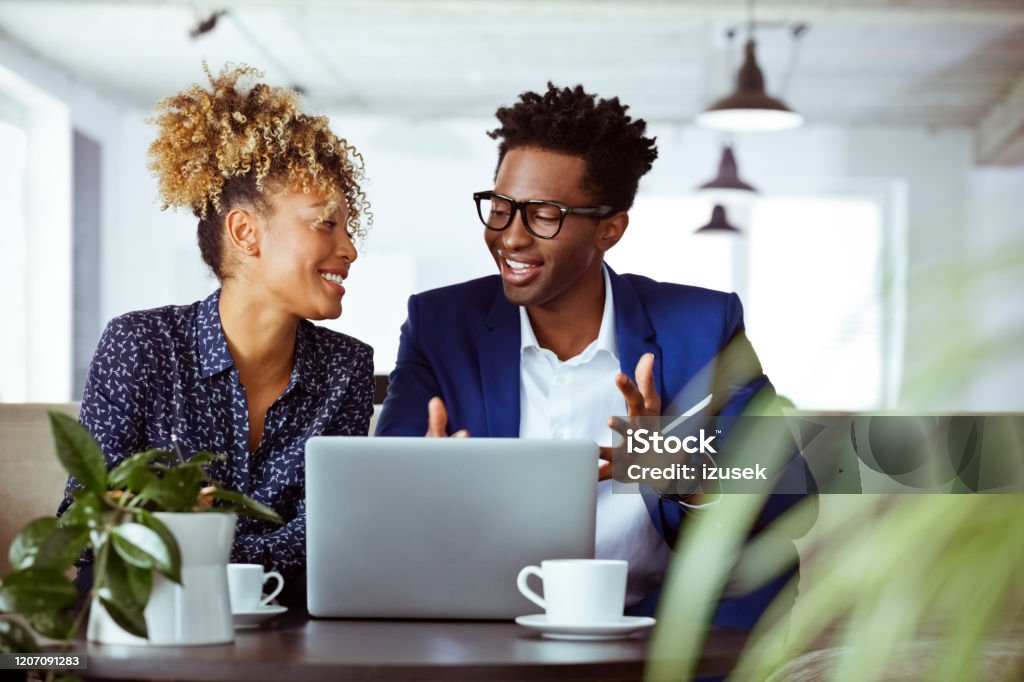 Businessman gesturing while talking to colleague Businessman gesturing while talking to colleague. Financial advisors are working in team at office. They are smiling. 30-34 Years Stock Photo