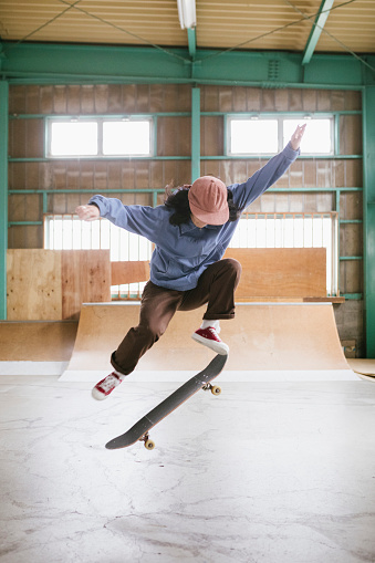 Young female skateboarder practicing her skills in a indoor skatepark in Tokyo.