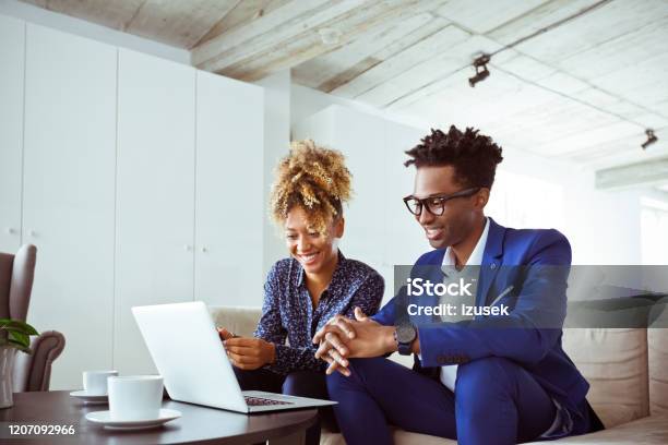 Confident Business Colleagues Looking At Laptop Stock Photo - Download Image Now - Working, Strategy, 30-34 Years