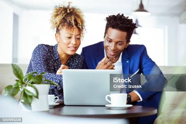 Financial Advisors Smiling While Using Laptop Stock Photo - Download Image Now - African-American Ethnicity, Business Meeting, Computer