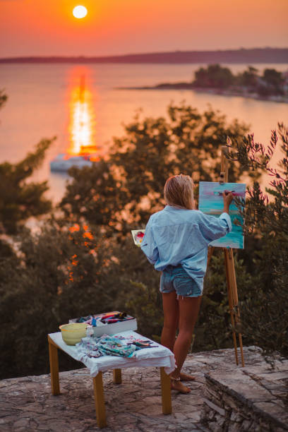 istock Beautiful young woman painting 1207093253