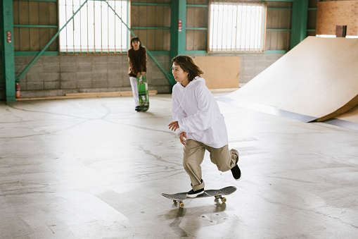 Young skateboarder practicing her skills in a skatepark in Tokyo.