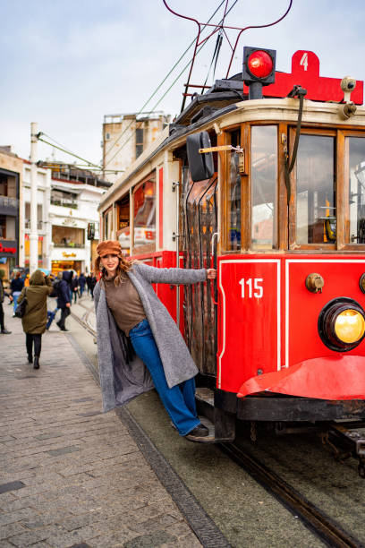 istock girl in coat stand running Board red tram 1207095399