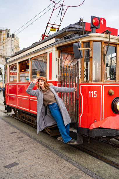 istock girl in coat stand running Board red tram 1207095577