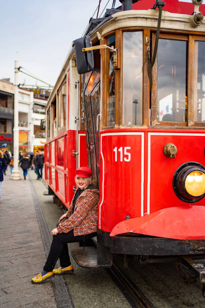 istock blond girl in jacket sit running Board red tram 1207095684