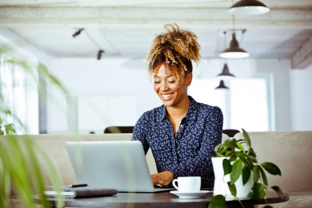 Smiling businesswoman using laptop in office