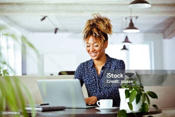 Smiling Businesswoman Using Laptop In Office Stock Photo - Download Image Now - Office, Laptop, Financial Advisor