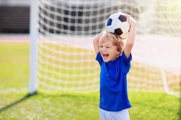 les enfants jouent au football. enfant au terrain de football. - playing field kids soccer goalie soccer player photos et images de collection