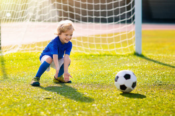 les enfants jouent au football. enfant au terrain de football. - playing field kids soccer goalie soccer player photos et images de collection