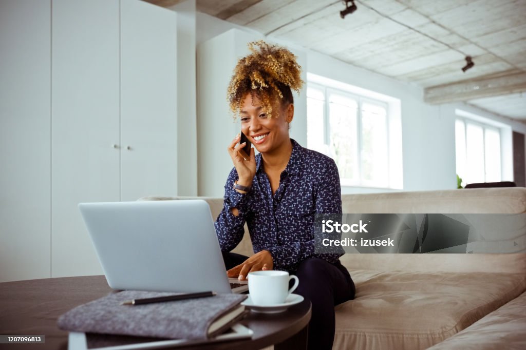 Worker dealing with client through mobile phone Smiling white collar worker dealing with client through mobile phone. Female corporate expert is working in office. She is related to financial occupation. Office Stock Photo