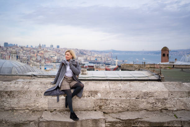 istock blonde in grey coat sit against roofs  Istanbul 1207097199