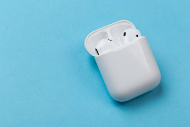 istock white wireless headphones with microphone on a blue background with charger 1207097540