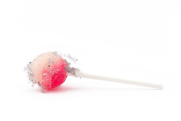A pink and white lollipop covered in fuzz, fluff and dirt - The Fuzzy End of the Lollipop