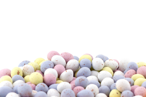 A heap of Mini Chocolate Eggs in various pastel shades, on white