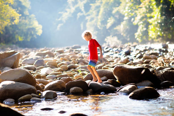 istock Child hiking in mountains. Kids at river shore. 1207098801