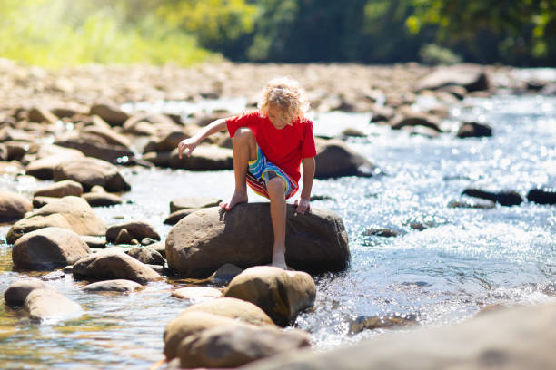 istock Child hiking in mountains. Kids at river shore. 1207099049