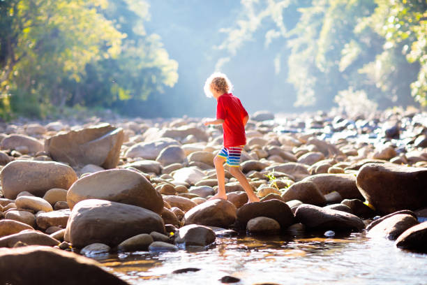 istock Child hiking in mountains. Kids at river shore. 1207101485