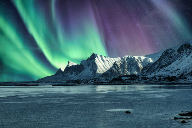 aurora boreal, luzes do norte acima da montanha nevada nas ilhas lofoten - norway lofoten and vesteral islands sea mountain range - fotografias e filmes do acervo