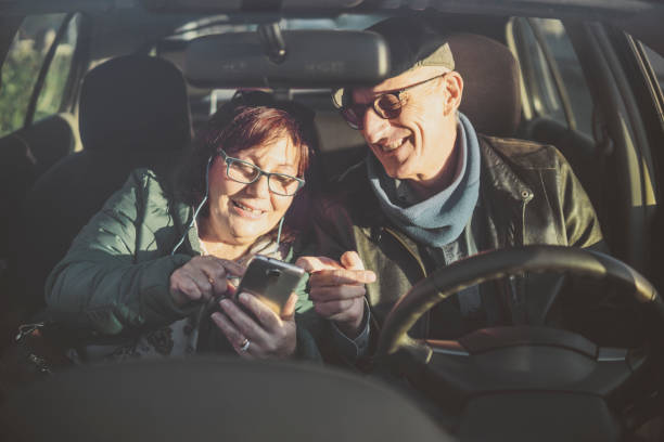 istock Retired couple enjoying time traveling - middle-aged couple having fun together using smartphone before leaving - happy mature people enjoying technology - warm contrast filter 1207103381