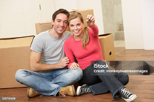 Foto de Jovem Casal Sentado Com Caixas Segurando A Chave Em Mãos e mais fotos de stock de 30 Anos