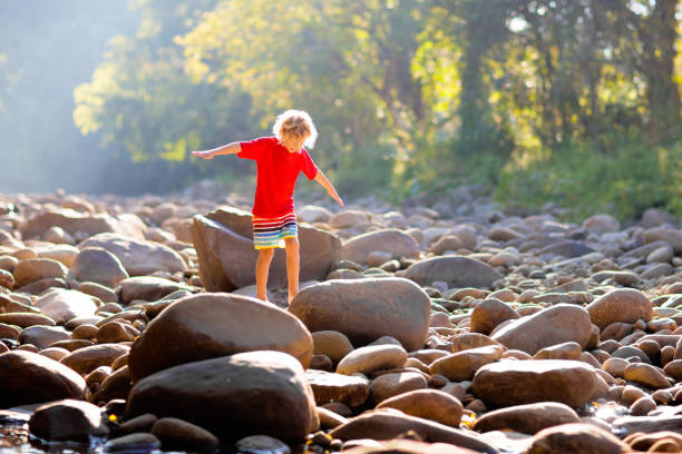 istock Child hiking in mountains. Kids at river shore. 1207104334