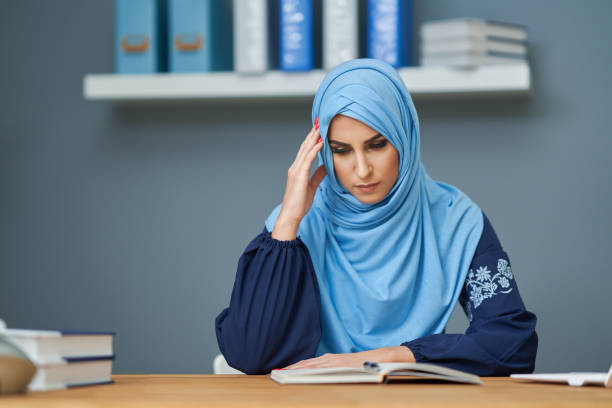 istock Unhappy muslim female student learning at home 1207104561