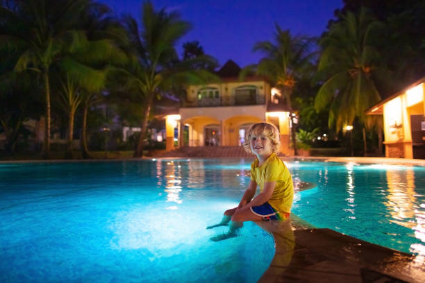istock Kids in swimming pool at night 1207106199