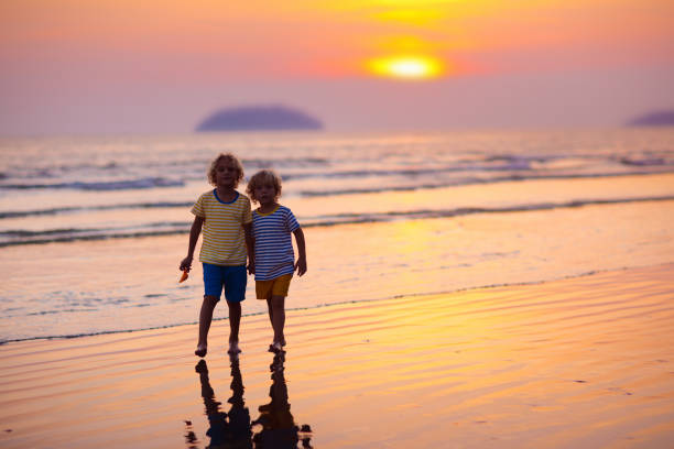 istock Child playing on ocean beach. Kid at sunset sea. 1207109343