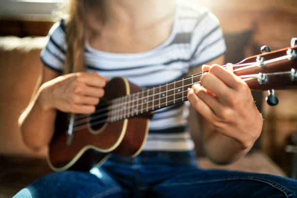 nahaufnahme von teenager-mädchen spielen ukulele - uke stock-fotos und bilder
