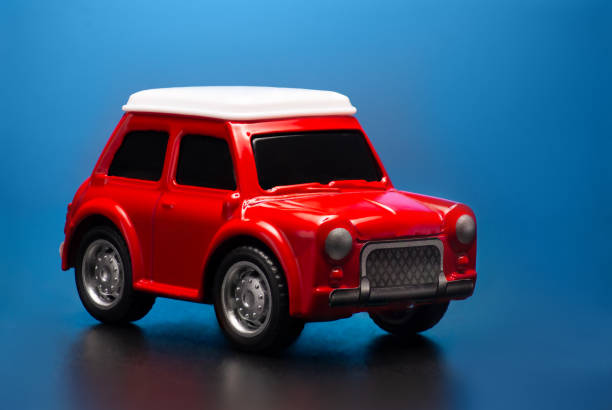 istock Red colored little toy model car on a blue background. 1207109576